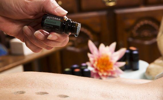 Aromatouch Behandeling. Olie wordt op rug gedruppeld