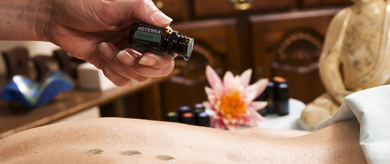 Aromatouch Behandeling. Olie wordt op rug gedruppeld